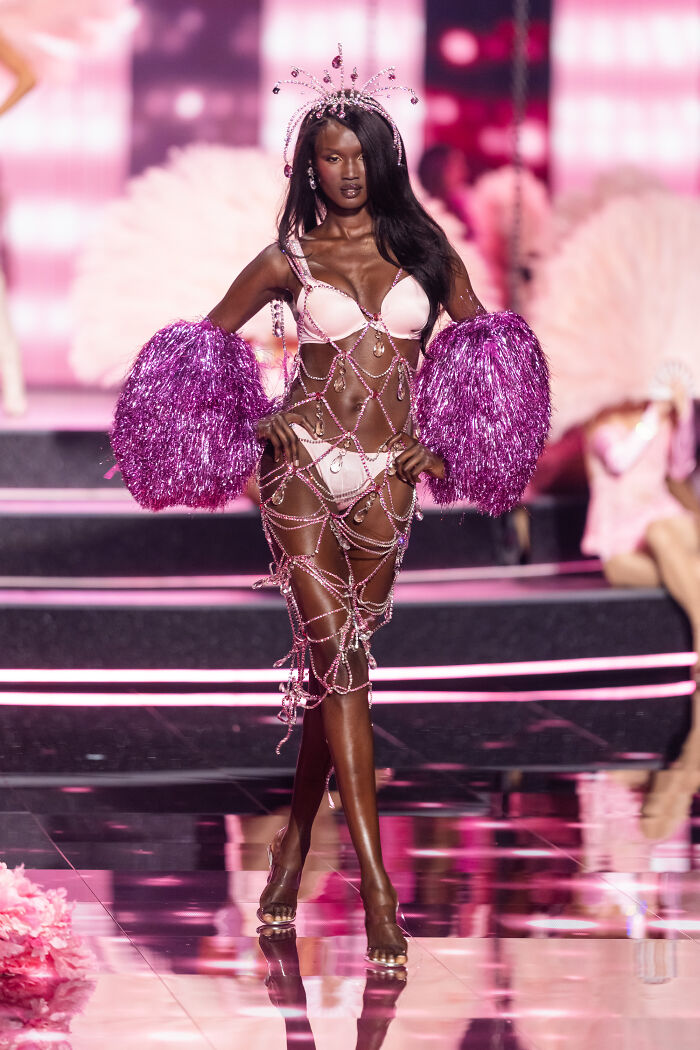 Model wearing pink lingerie and decorative accessories walking the runway at Victoria's Secret fashion show 2025.