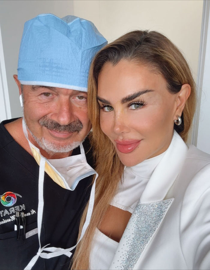 Actress with doctor after controversial eye color change surgery risking blindness smiling in a close-up photo.