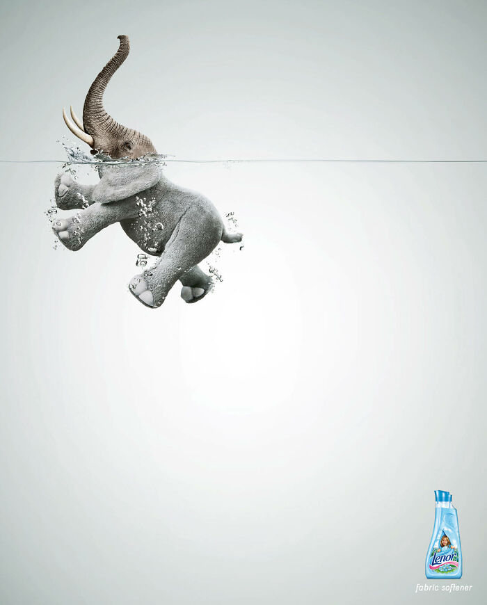 Elephant submerged in water with bubbles, next to a fabric softener bottle, creative ad featuring elephants concept.
