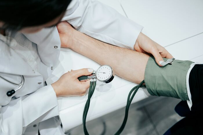 Doctor measuring blood pressure of patient, illustrating terrifying medical conditions that show no symptoms but can be fatal.