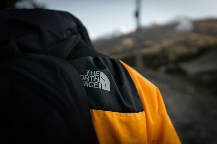 Close-up of a black and yellow jacket with The North Face logo, symbolizing endurance related to longest grudges held.