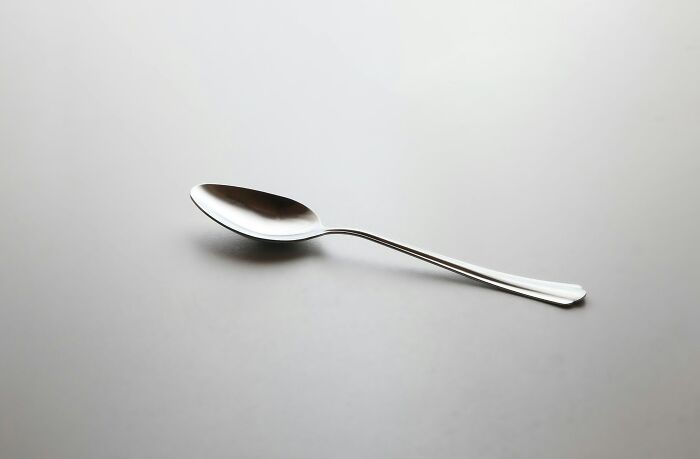 Silver spoon on a plain surface representing strange and dumb health hacks shared by patients with doctors or nurses
