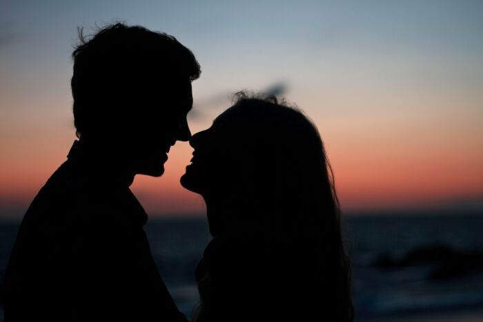 Silhouette of a couple close together at sunset, illustrating relationship advice for couples in a romantic setting.
