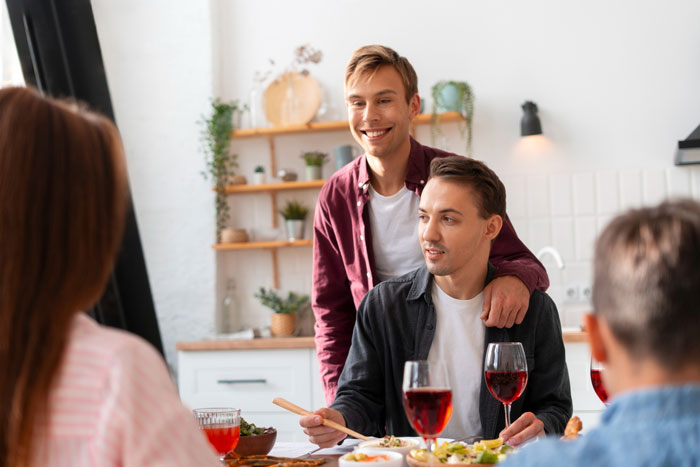 Young family having dinner together, tense atmosphere hinting at conflict over racist slurs during meal.