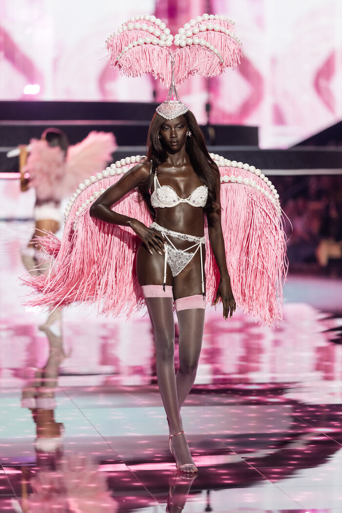 Model in elaborate pink feather and pearl costume walking the runway during Victoria's Secret fashion show 2025 stunning looks.