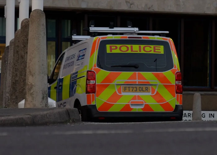 Police van parked outside a building related to the fatal attack on a rock star serving prison time for crimes against children.