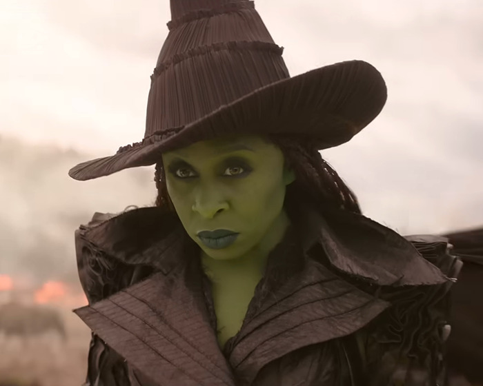 Ariana Grande with dramatic green makeup and dark hat, showcasing a bold new look that sparks fan backlash.