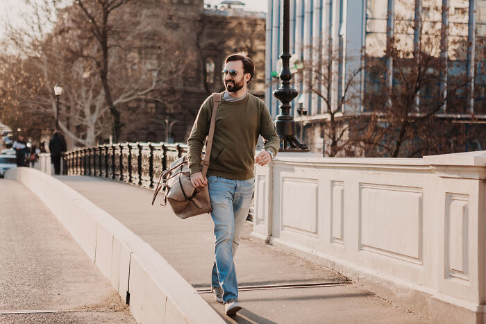 Man in sunglasses and casual clothes walking confidently by a city street exploring loopholes advantage ideas outdoors.