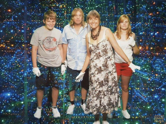 Family posing awkwardly in a colorful mirrored room, creating one of the family photos laughed or cringed at online.