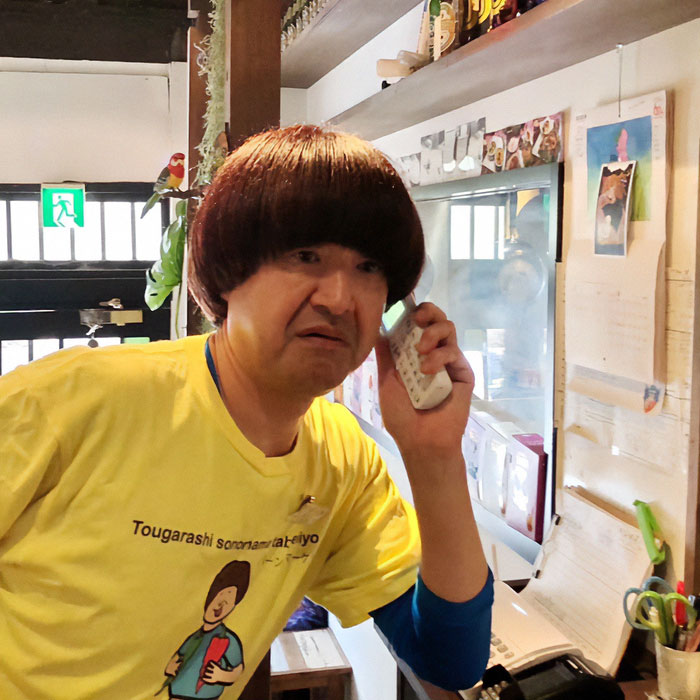 Man in yellow shirt talking on phone inside a Japanese restaurant amid tourists kicked out over revealing sports attire debate Man in yellow shirt talking on phone inside a Japanese restaurant amid tourists kicked out over revealing sports attire debate