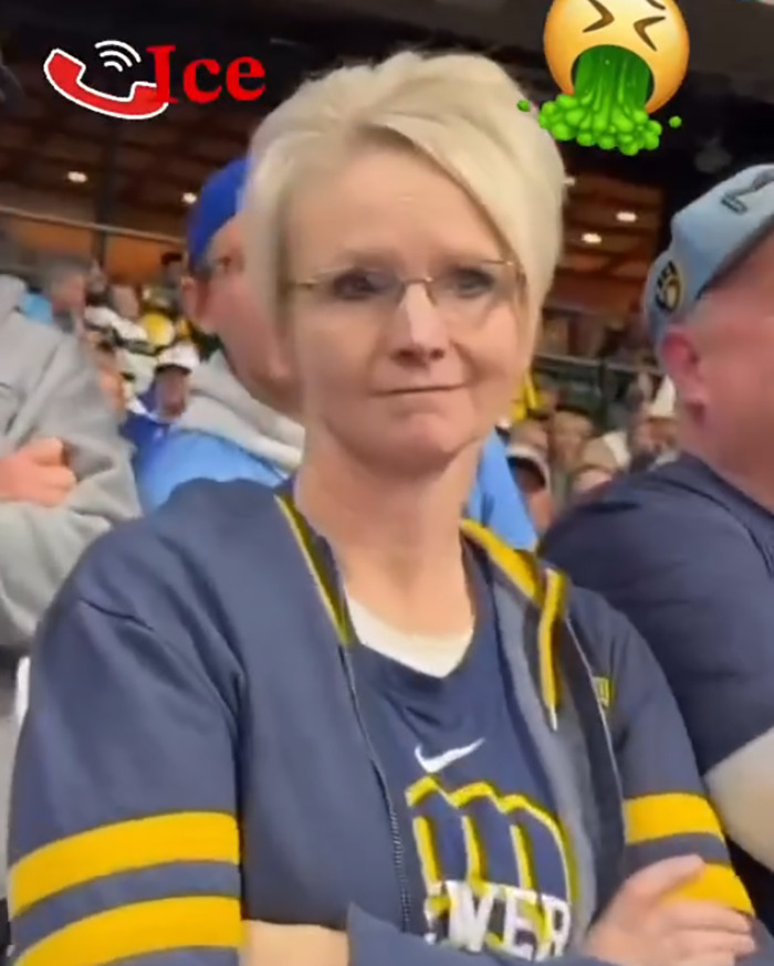 Woman at a baseball game wearing glasses and a Brewers jersey, known as the baseball Karen involved in racist rant controversy.