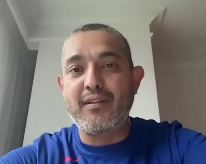 Man with short hair and beard wearing a blue shirt speaking in a video related to baseball Karen fired incident.