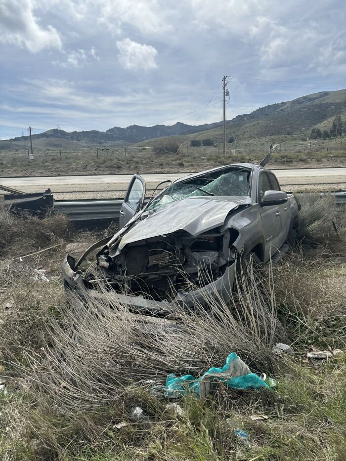 Crashed car off road with severe front damage and shattered windshield in a nightmare survival situation on a rural roadside.