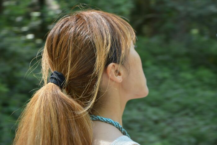 Woman with a ponytail outdoors, focusing on people sharing potentially dangerous situations in a natural setting.