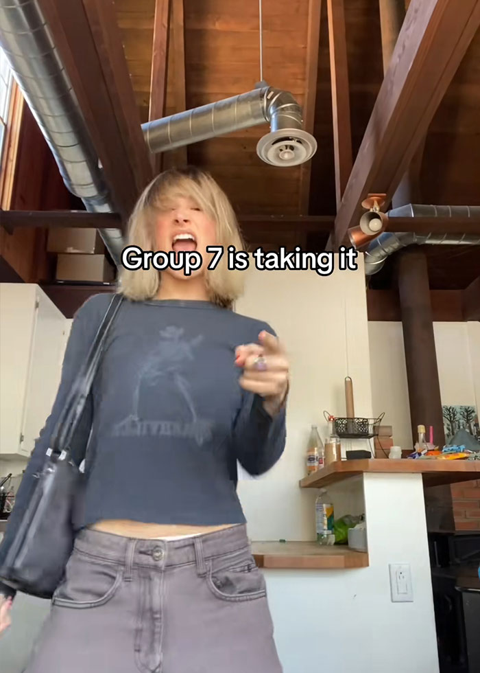 Person dancing energetically indoors with text about Group 7 blowing up on TikTok viral trend.