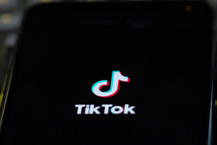 TikTok app open on a smartphone screen highlighting viral trend related to Group 7 blowing up on the platform.