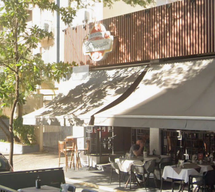 Outdoor caf&eacute; with tables and chairs under awning, capturing children come first concept in peaceful urban setting.