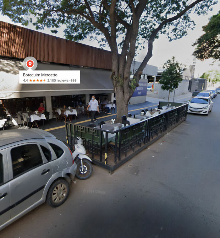 Outdoor restaurant seating area with tables and chairs beside a street, illustrating children come first concept.