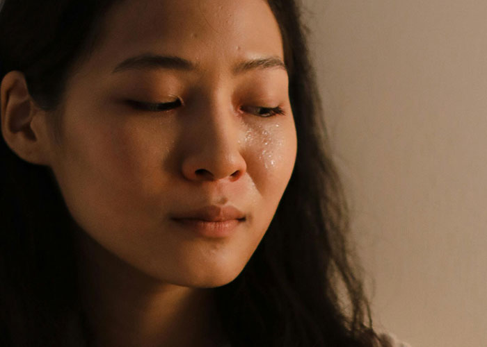 Young woman with tears on her face reflecting on a man with debt asking for a loan to buy a Spiderman costume.