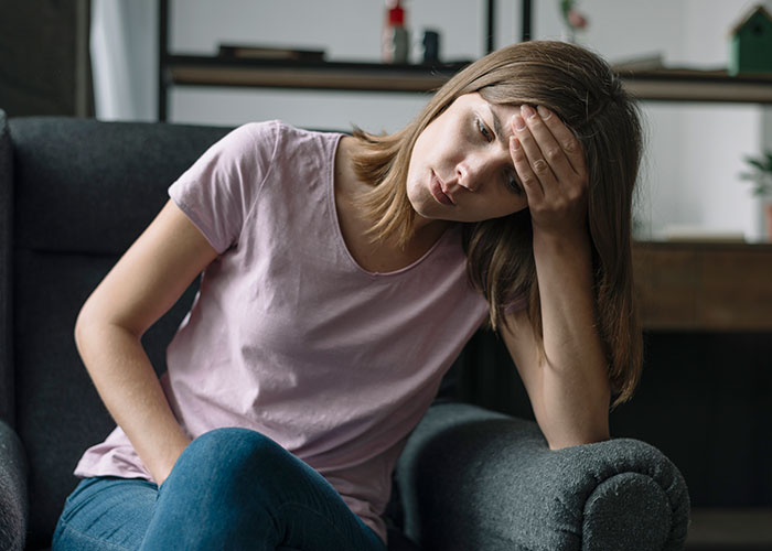 Woman sitting in a chair looking stressed and frustrated, reflecting on being called a gold digger for wanting fair chores.