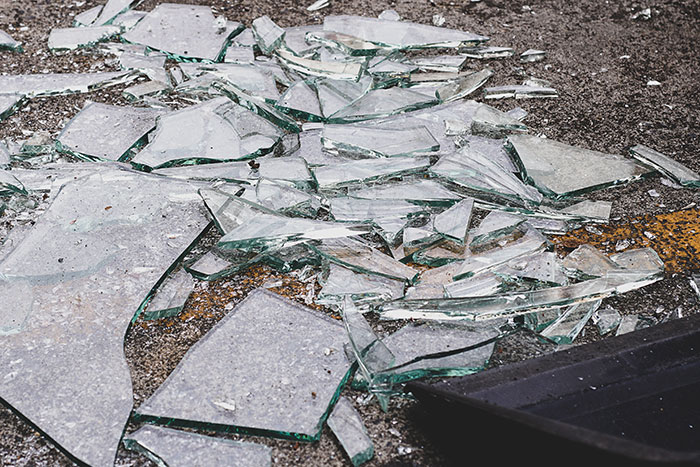 Broken shattered glass pieces on ground representing boyfriend destroyed girlfriends grandmas jewelry box incident.
