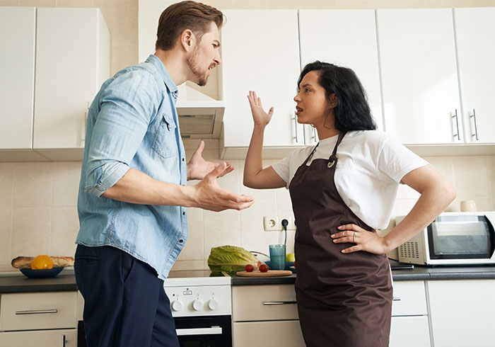 Woman in apron arguing with brother about live-in nanny job demands in kitchen setting