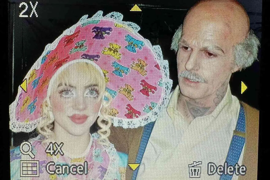 Celebrity dressed in unusual Halloween costume with playful pink hat and man in old-fashioned outfit showing lack of common sense.