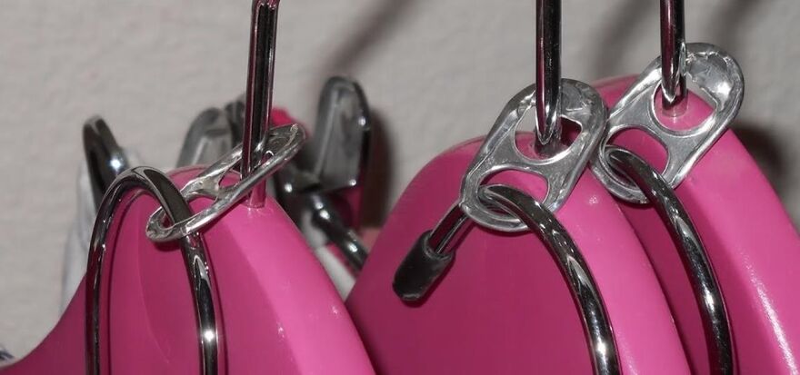 Close-up of metal hooks and pink plastic items arranged neatly as an organization hack for home storage.