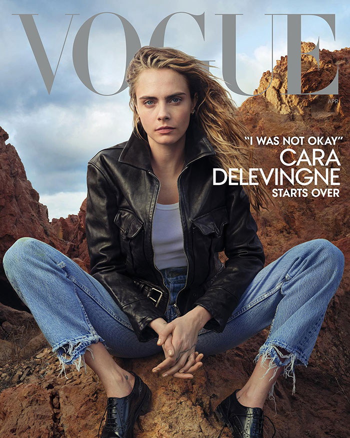 Cara Delevingne in a leather jacket and jeans sitting on rocks, representing Victoria&rsquo;s Secret models&rsquo; dark sides.