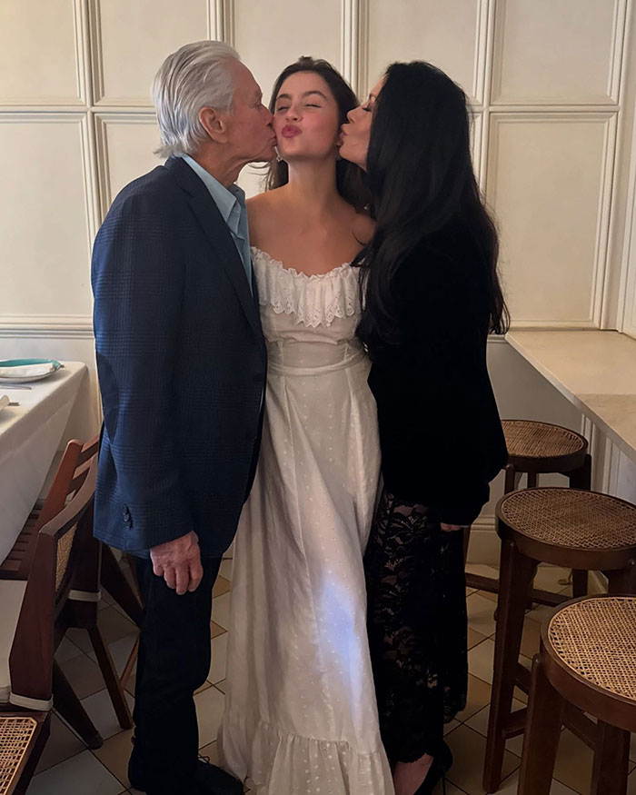 Catherine Zeta-Jones' daughter wearing a vintage 20-year-old dress, sharing a moment with two adults at a gathering.
