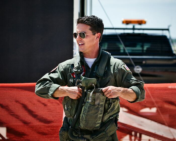 Man in military flight suit and sunglasses standing outdoors, related to longest grudges people have held.