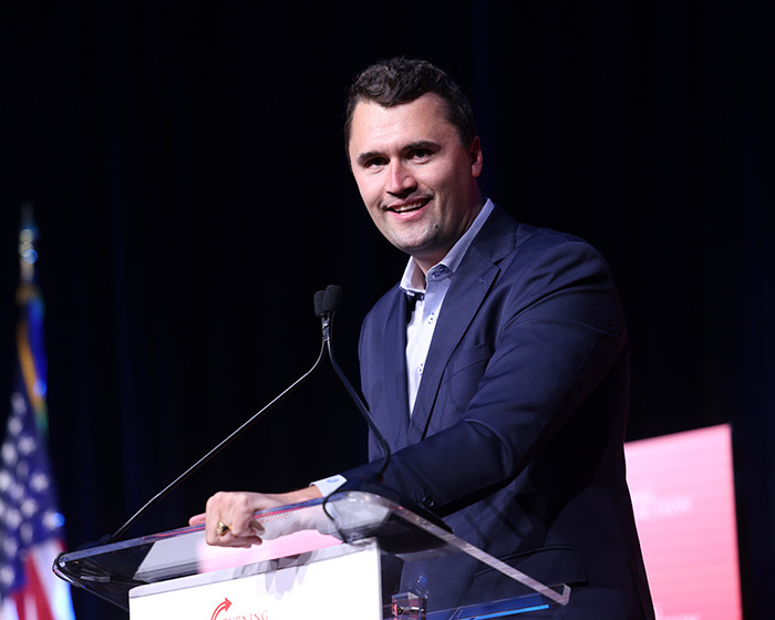 Charlie Kirk speaking at a podium in Michigan where billboards sparked hilarious reactions about birth control. Charlie Kirk speaking at a podium in Michigan where billboards sparked hilarious reactions about birth control.
