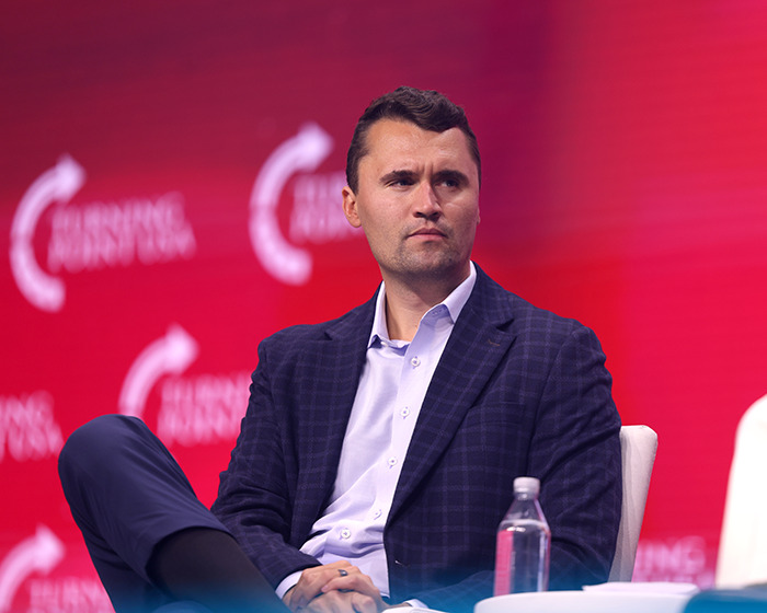 Man in a blue checkered blazer sitting on stage with a red backdrop, relating to inventive form of birth control discussion. Man in a blue checkered blazer sitting on stage with a red backdrop, relating to inventive form of birth control discussion.