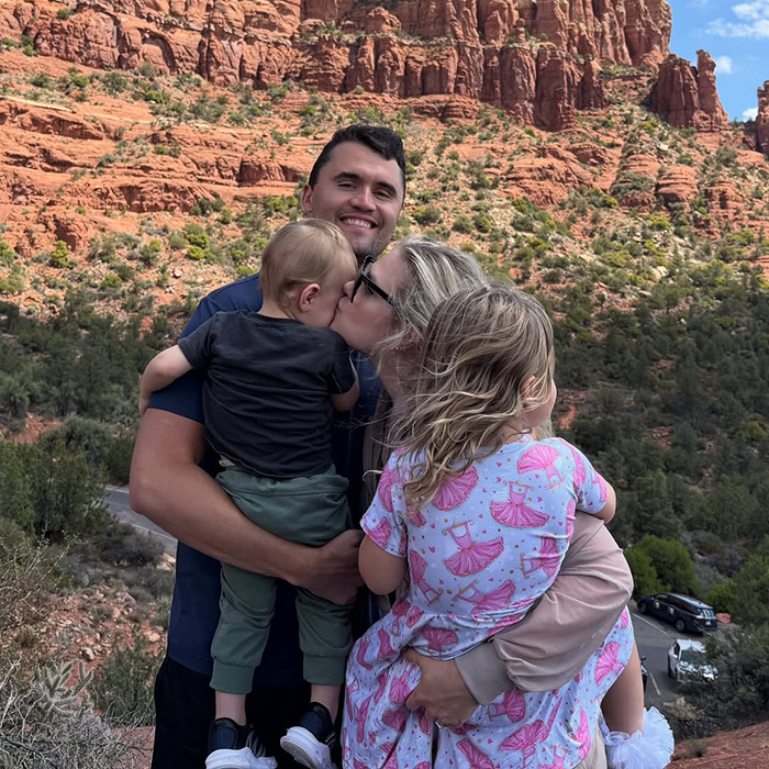 Family of four embracing outdoors with red rock formations, illustrating themes related to inventive birth control reactions. Family of four embracing outdoors with red rock formations, illustrating themes related to inventive birth control reactions.