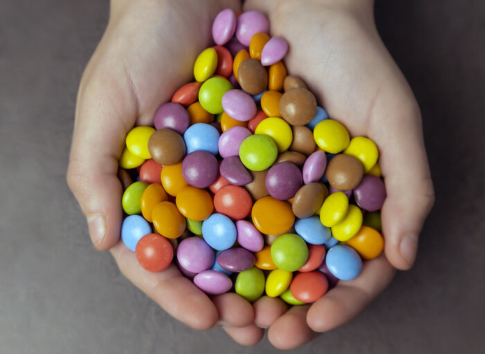 Hands holding a colorful mix of candy, illustrating accountants beating the boring job allegations with fun and crazy stories.