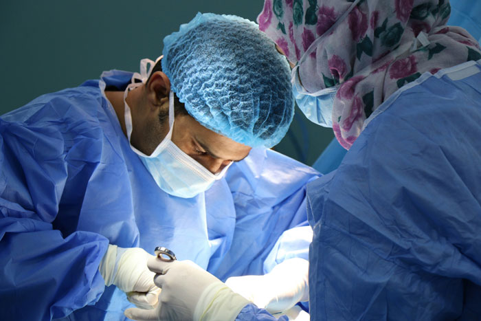 Surgeons focused on surgery in a sterile operating room, illustrating wife plans surgery after weight loss topic.