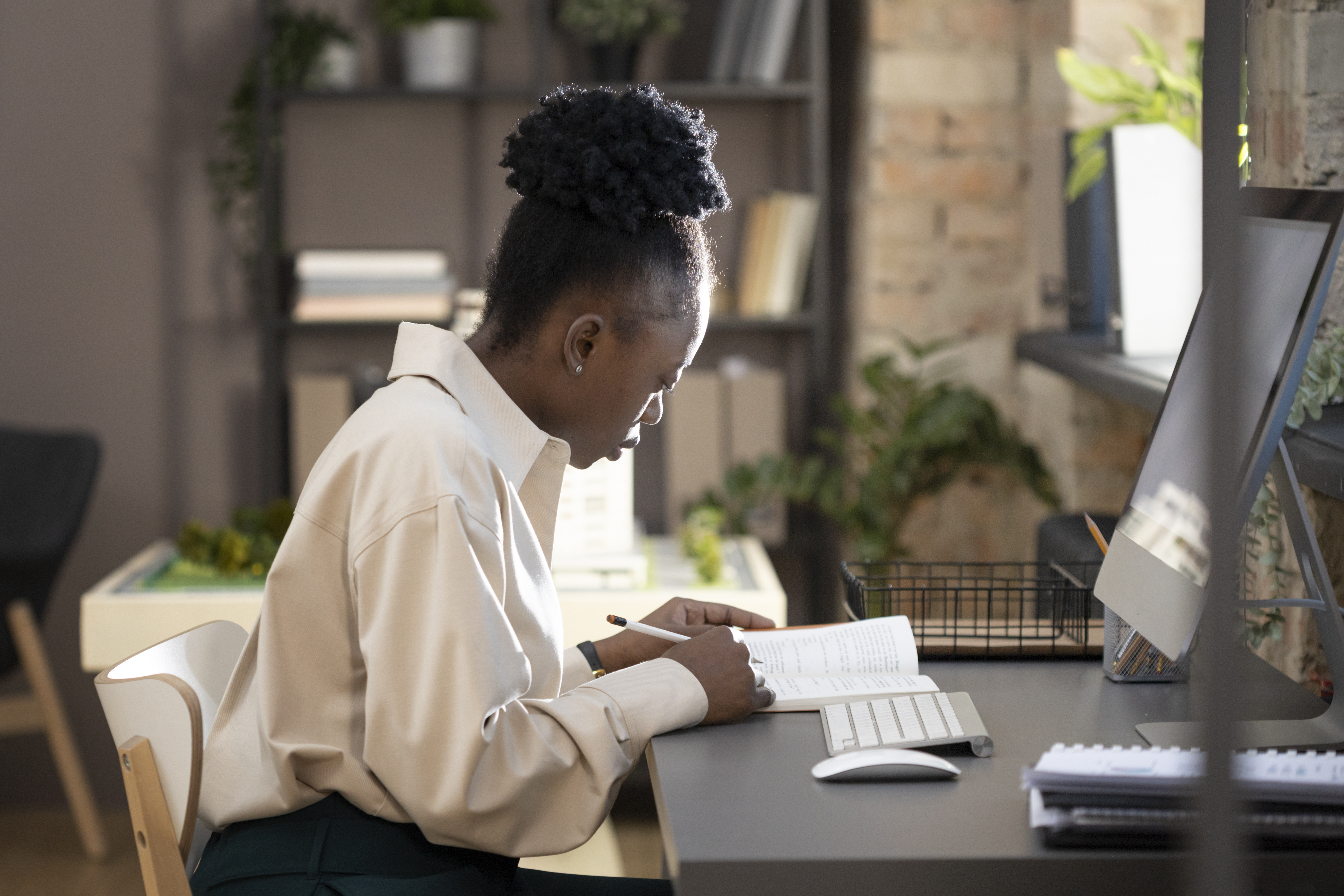 Woman working at desk in modern office, symbolizing job offers after changing to a white-sounding name.