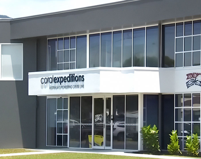 Coral Expeditions cruise company office building with glass windows, related to elderly woman stranded on remote island.