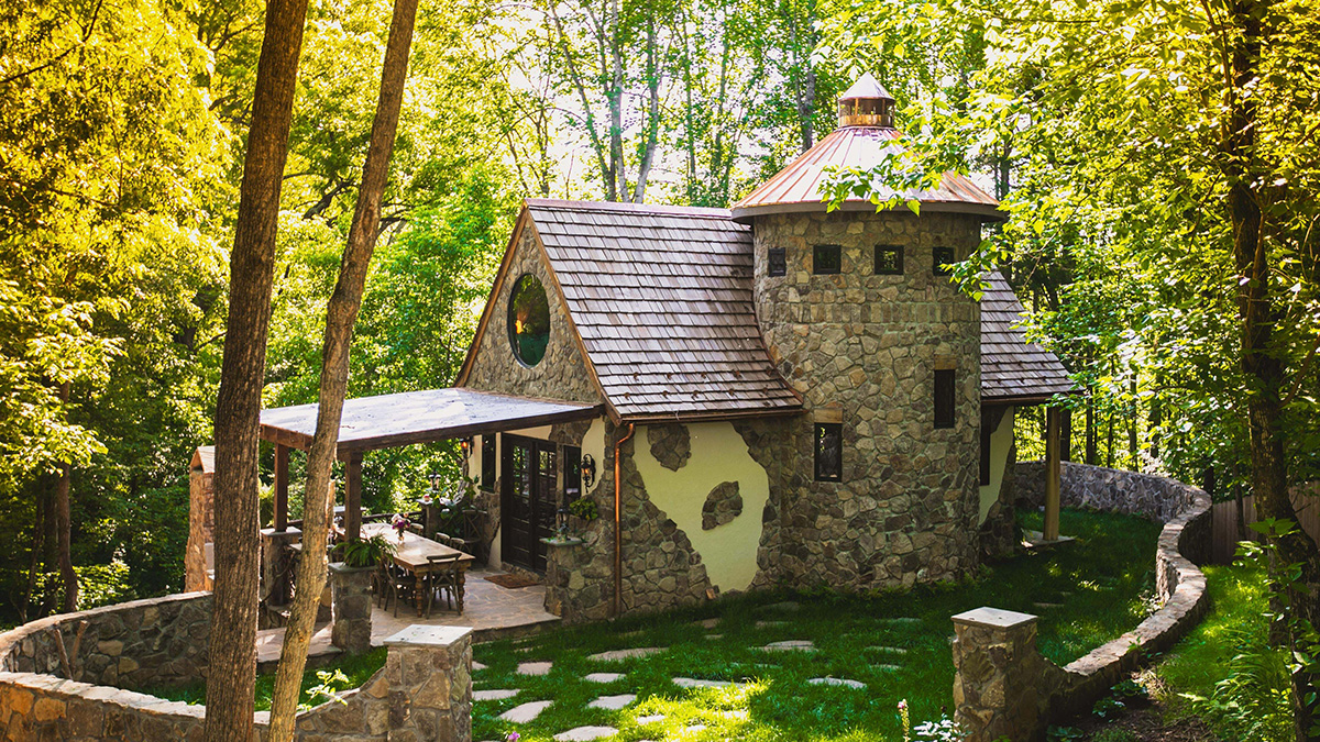 Stone cottage surrounded by lush greenery showcasing charming cottage core aesthetics in a peaceful forest setting