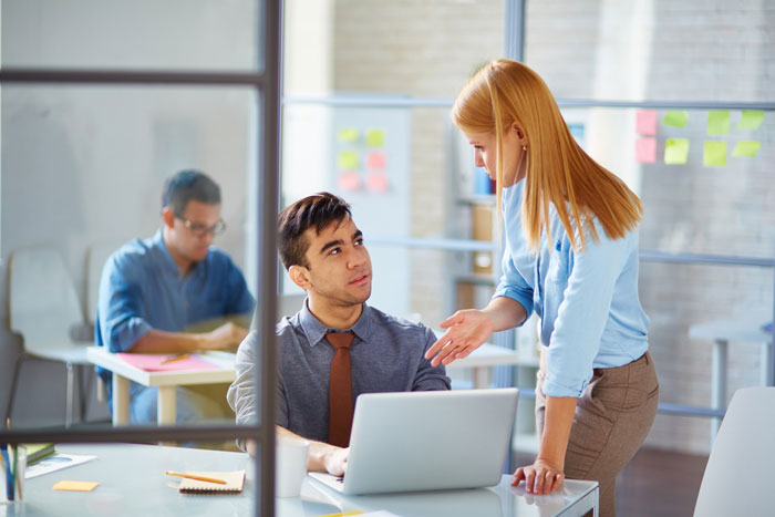 A coworker discussing sensitive smells with a colleague in an office setting, next to a laptop and notes. A coworker discussing sensitive smells with a colleague in an office setting, next to a laptop and notes.