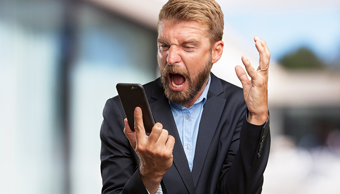 Angry rich man in a suit yelling at phone, portraying frustration related to firing babysitter with false accusations.