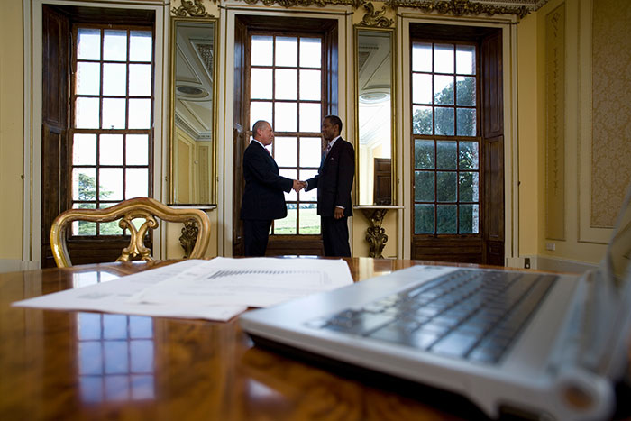 Two men in suits shaking hands in an office, illustrating a clear case of work nepotism at a professional level.