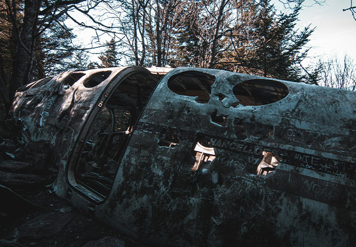 Abandoned, decaying wreckage in a dark forest, evoking the creepiest found footage and chilling video stories.