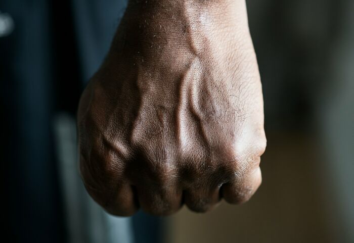Close-up of a clenched fist with visible veins, symbolizing strength and emotions in near-death experiences.