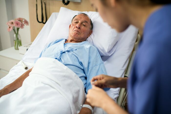 Elderly man in hospital bed experiencing near-death moments while nurse comforts him in a medical setting.