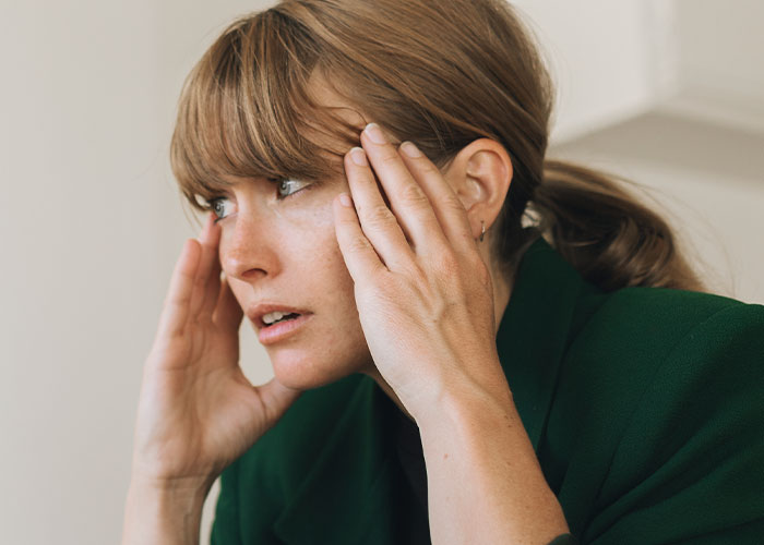 Worried woman holding her head, reacting to dad upset about daughter&rsquo;s home and saying something weird.