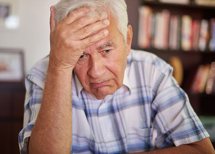 Elderly man looking upset and worried at home, illustrating a dad upset about daughter&rsquo;s home and concern.