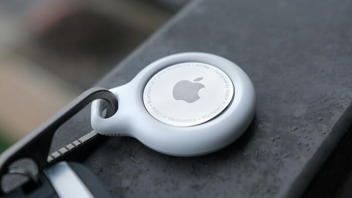 Apple AirTag keychain placed on a dark surface, illustrating tracking and unhinged stalking stories by women.