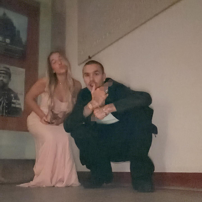 Man squatting next to woman in a long dress indoors, unrelated to David Beckham or creepy relationship keywords.