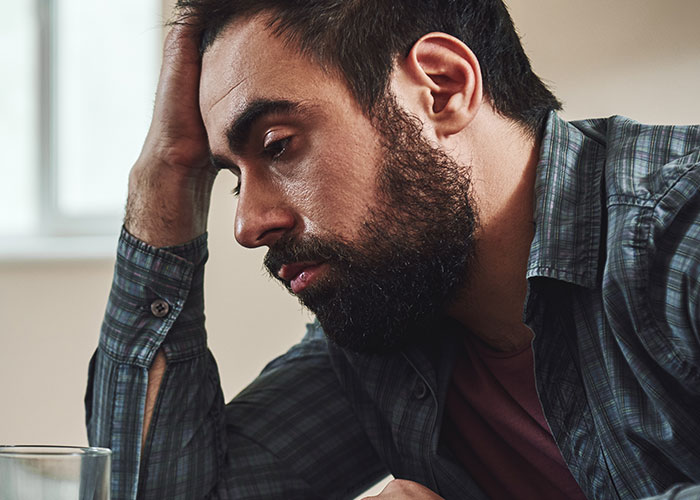 Man looking distressed and overwhelmed, representing the emotional impact of being a villain in someone else’s story.